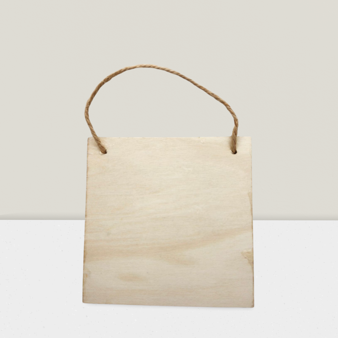 Plain wooden sign with a string for hanging on a light gray background