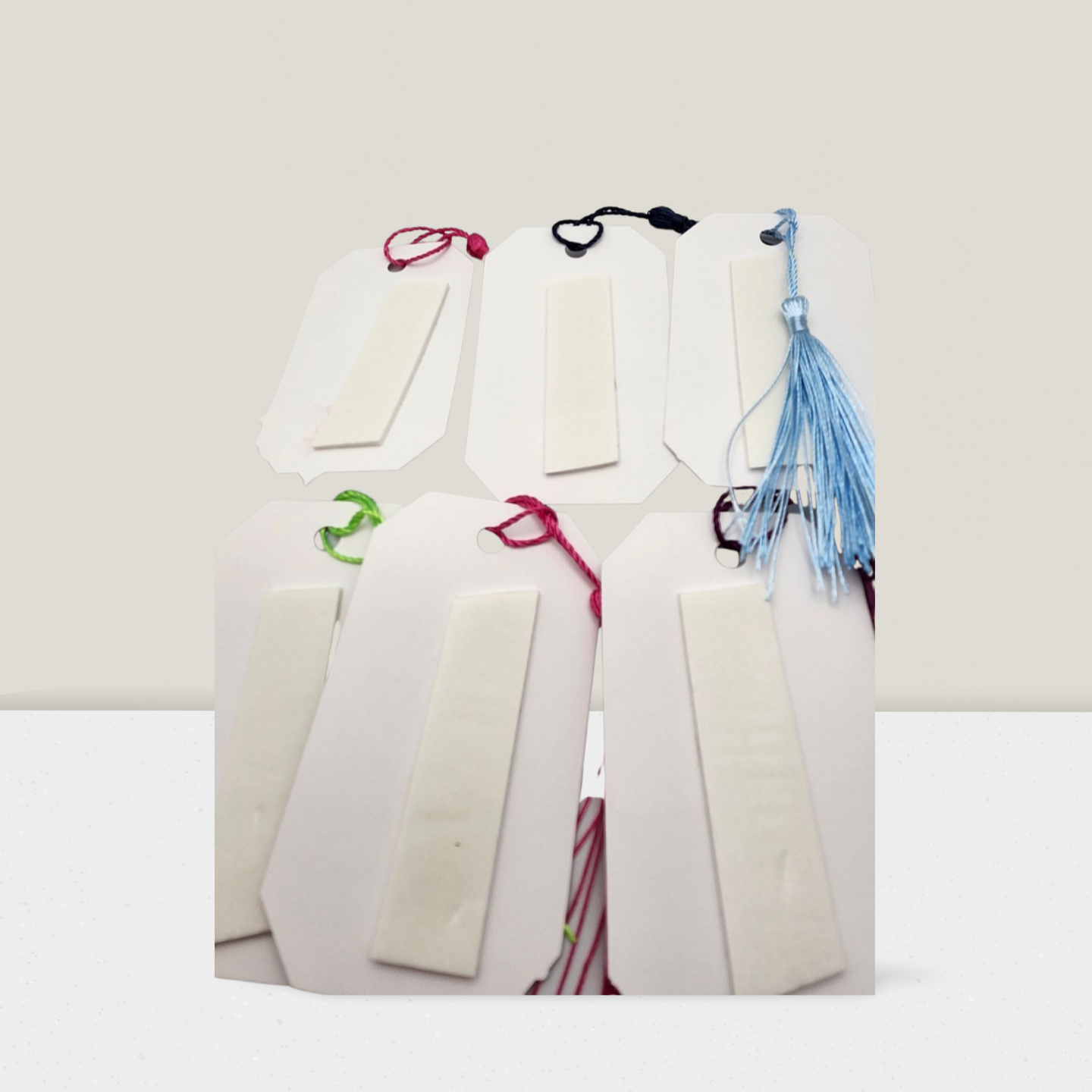 White gift bags with colorful ribbons on a white background