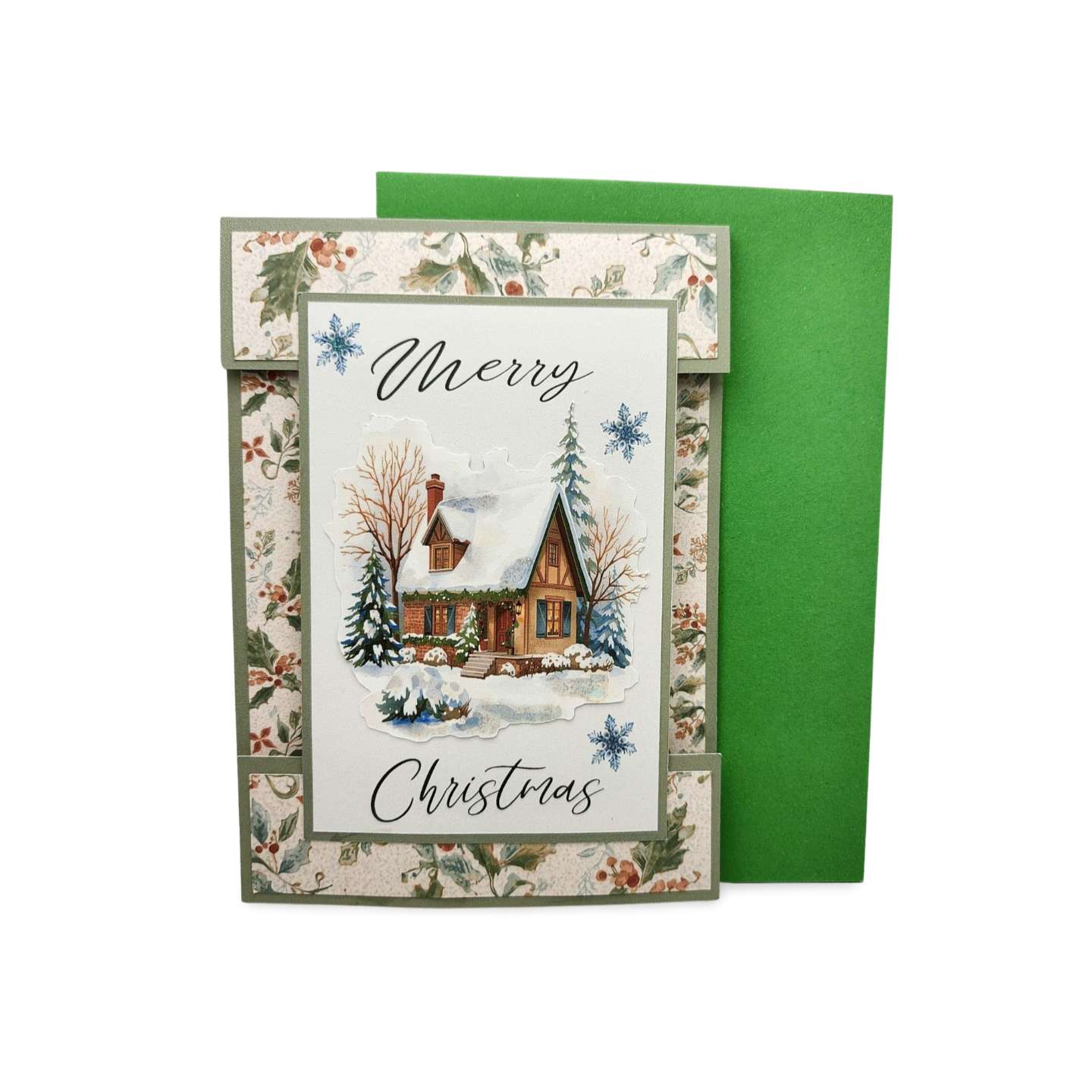 Christmas card with a snowy village scene and 'Merry Christmas' text, featuring a green envelope.