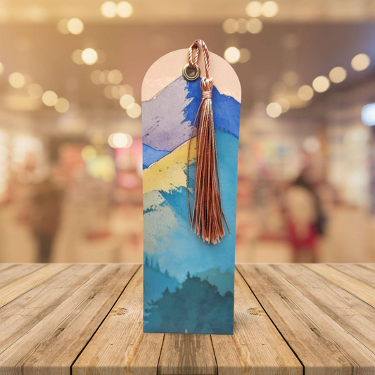 Decorative bookmark with tassel on a wooden surface with a blurred background