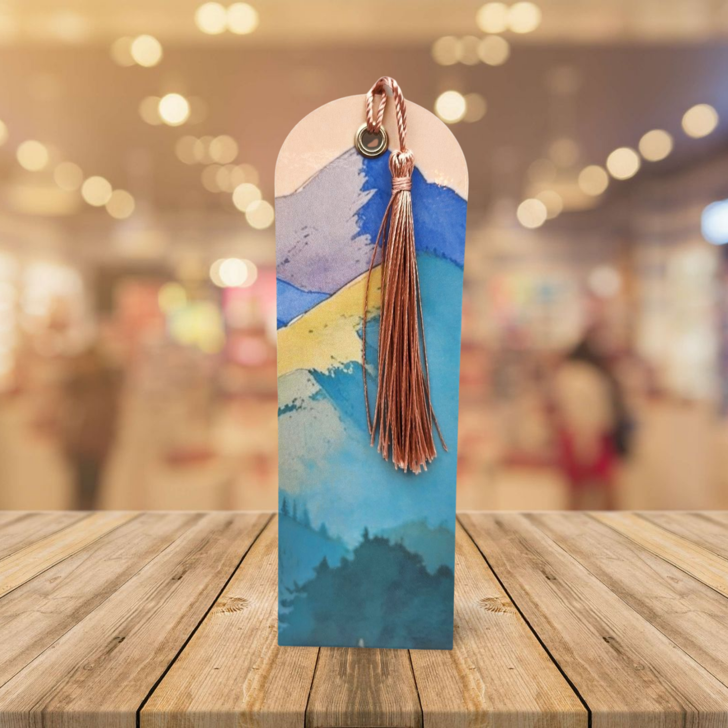 Decorative bookmark with tassel on a wooden surface with a blurred background