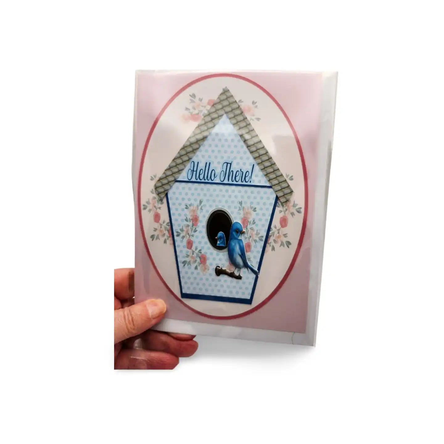 Card with a birdhouse design and 'Hello There!' text, held by a hand on a white background