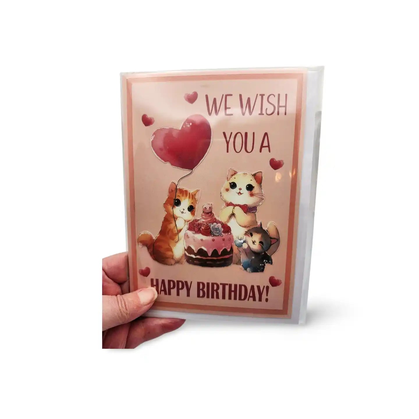Hand holding a birthday card with cartoon cats and cake design on a white background