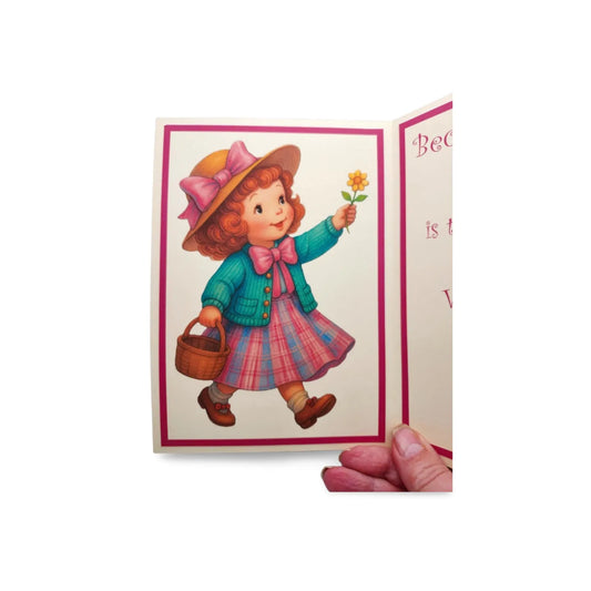 Vintage-style greeting card with a girl holding a flower and a basket.