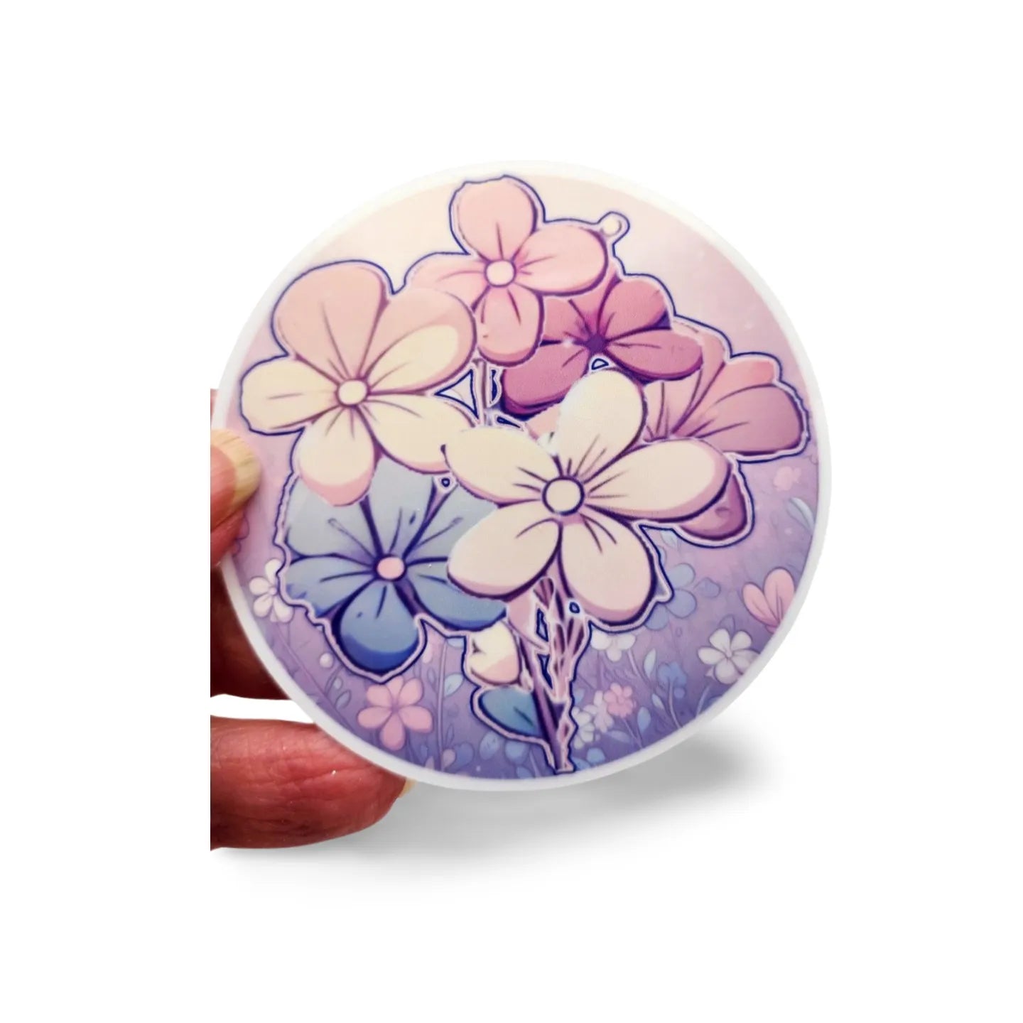 Floral design on a round object held by a hand against a white background
