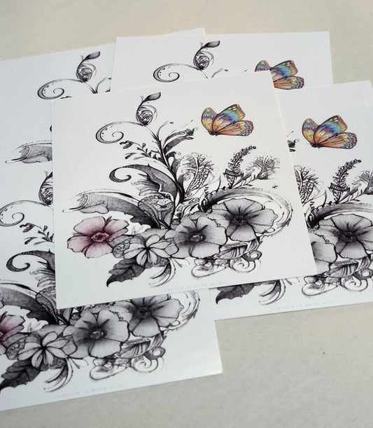 Floral and butterfly temporary tattoos on white paper with a beige background