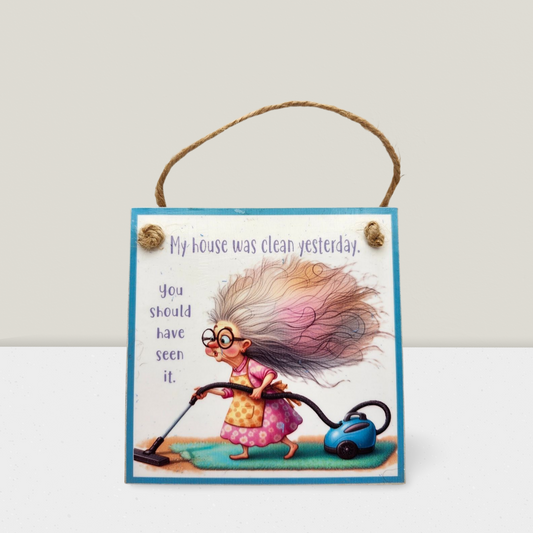 Decorative sign with cartoon character cleaning a floor, text 'My house was clean yesterday. You should have seen it.'
