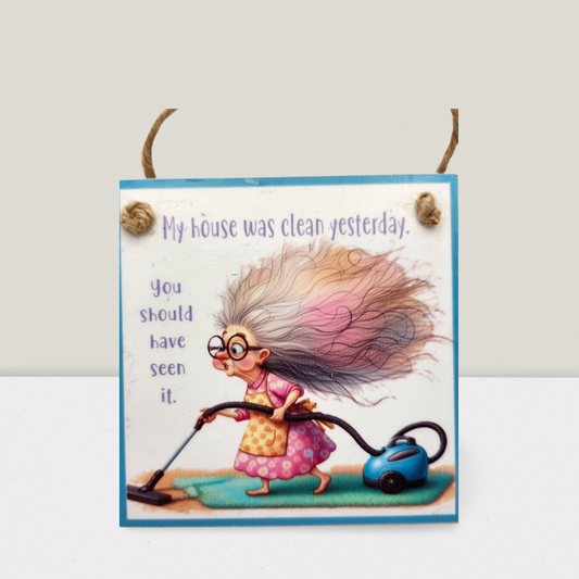Cartoon character with long hair using a vacuum cleaner on a sign with humorous text.