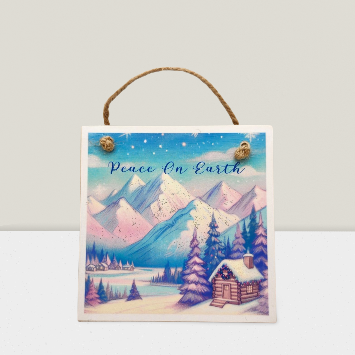 Decorative sign with a winter landscape and 'Peace On Earth' text on a white background