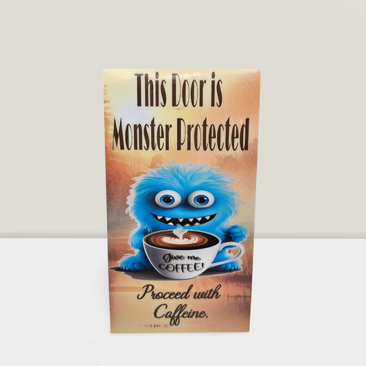 Door sign with a cartoon monster holding a coffee cup and text 'This Door is Monster Protected. Proceed with Caffeine.'