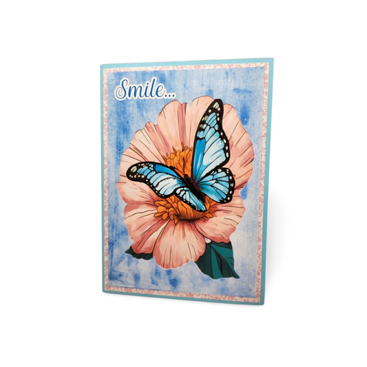 Card with a butterfly on a flower and the word 'Smile' on a blue watercolor background