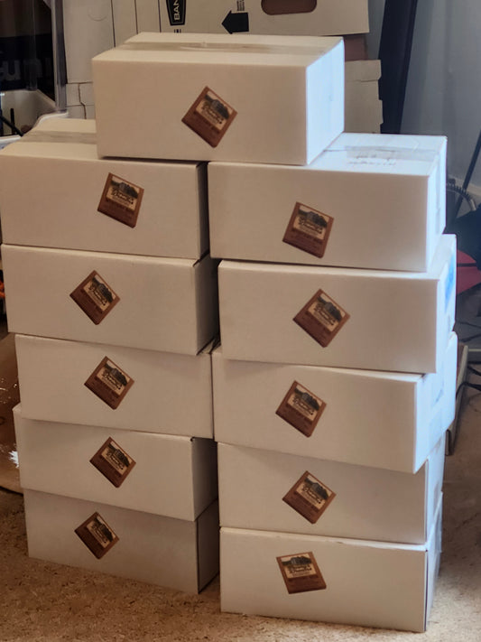 Stack of white boxes with a logo on a textured surface