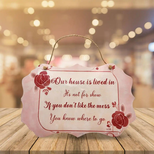 Decorative sign with a quote on a wooden surface with a blurred background