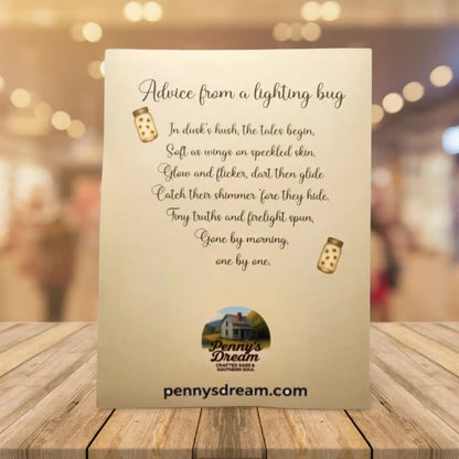 Card with poem 'Advice from a lightning bug' by Penny's Dream on a wooden surface with blurred background