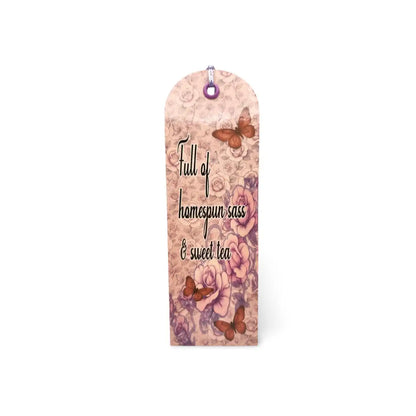 Decorative bookmark with floral design and text on a white background