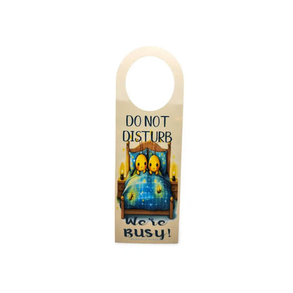 Door hanger with cartoon characters in bed and text 'Do Not Disturb, We're Busy!' on a white background