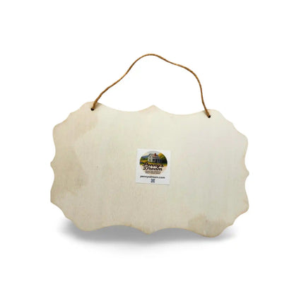 Decorative white scalloped sign with a hanging string on a white background