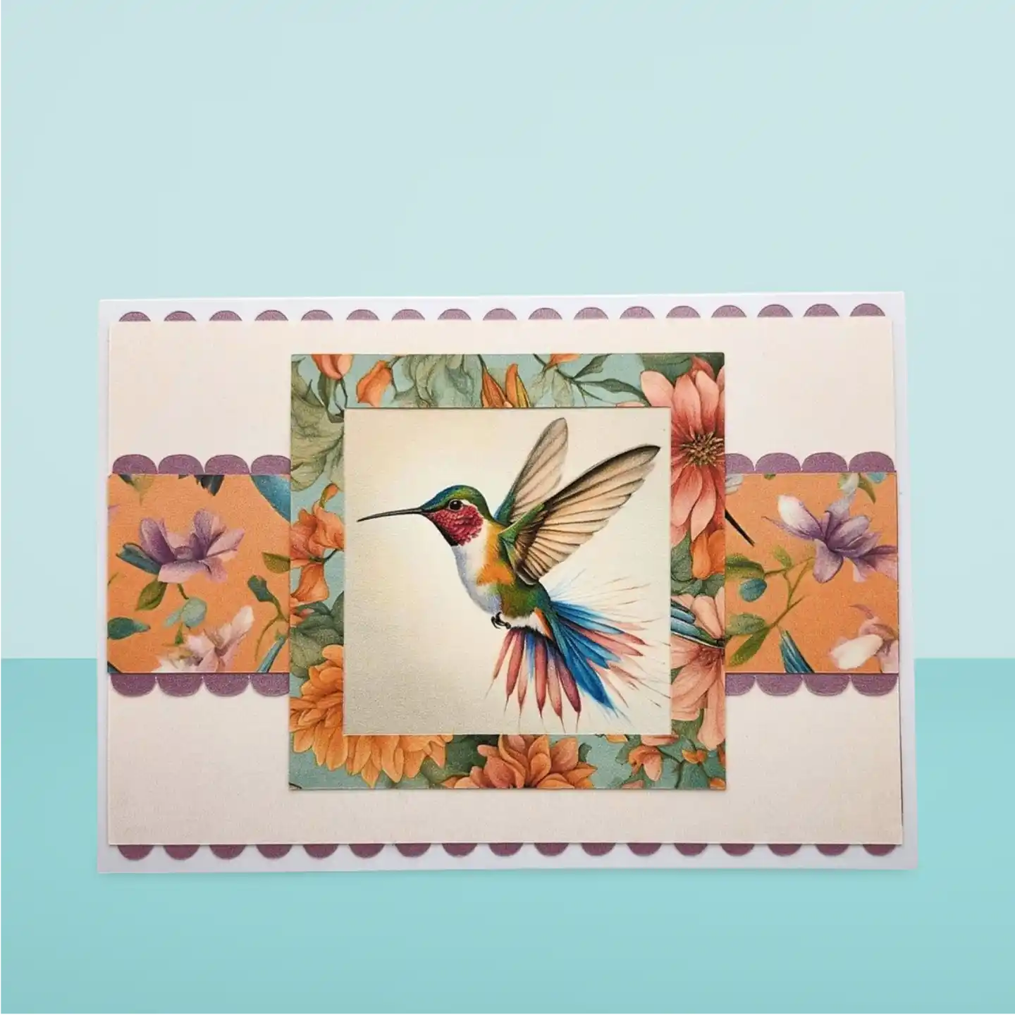 Card with a colorful illustration of a hummingbird and flowers on a light blue background