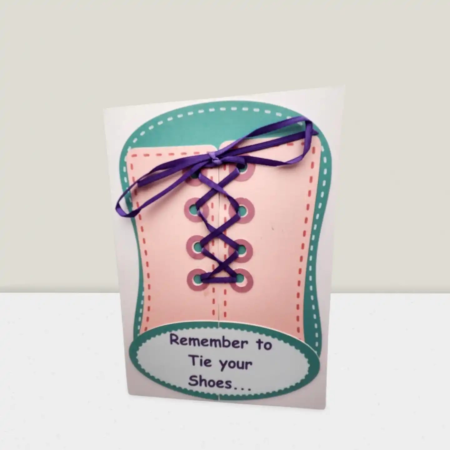 Card shaped like a shoe with laces and text 'Remember to Tie your Shoes' on a white background