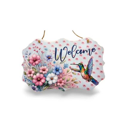 Decorative sign with flowers and a hummingbird, featuring the word 'Welcome'.