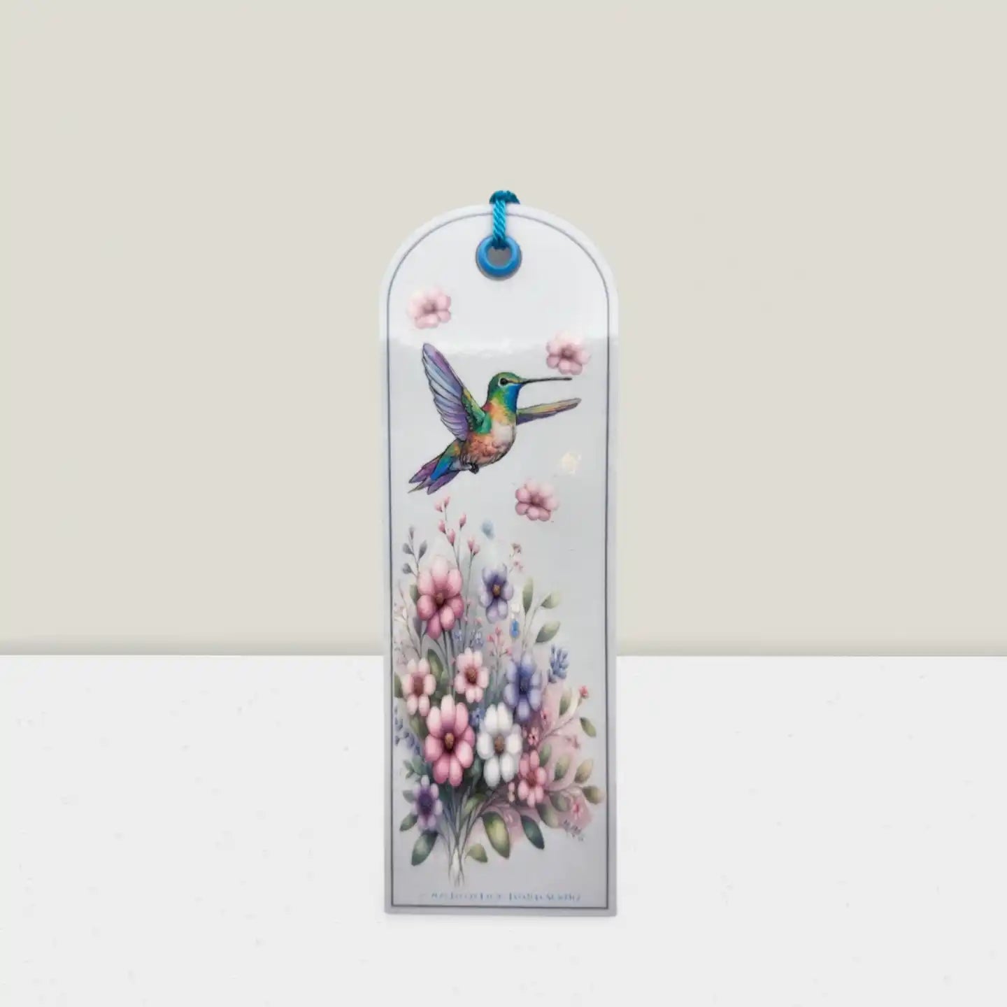 Decorative bookmark with a hummingbird and floral design on a white background
