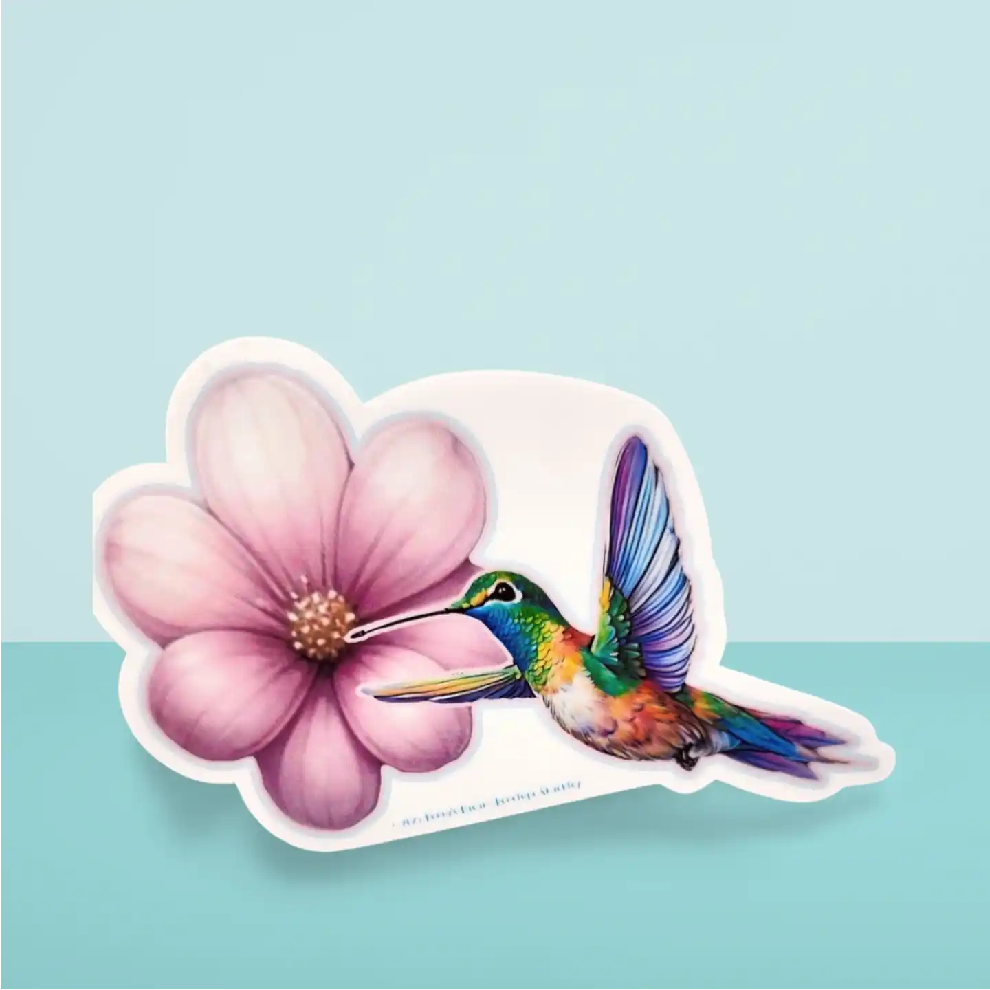 Sticker of a colorful hummingbird and pink flower on a light blue background