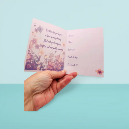 Hand holding a card with floral design and text on a light blue background