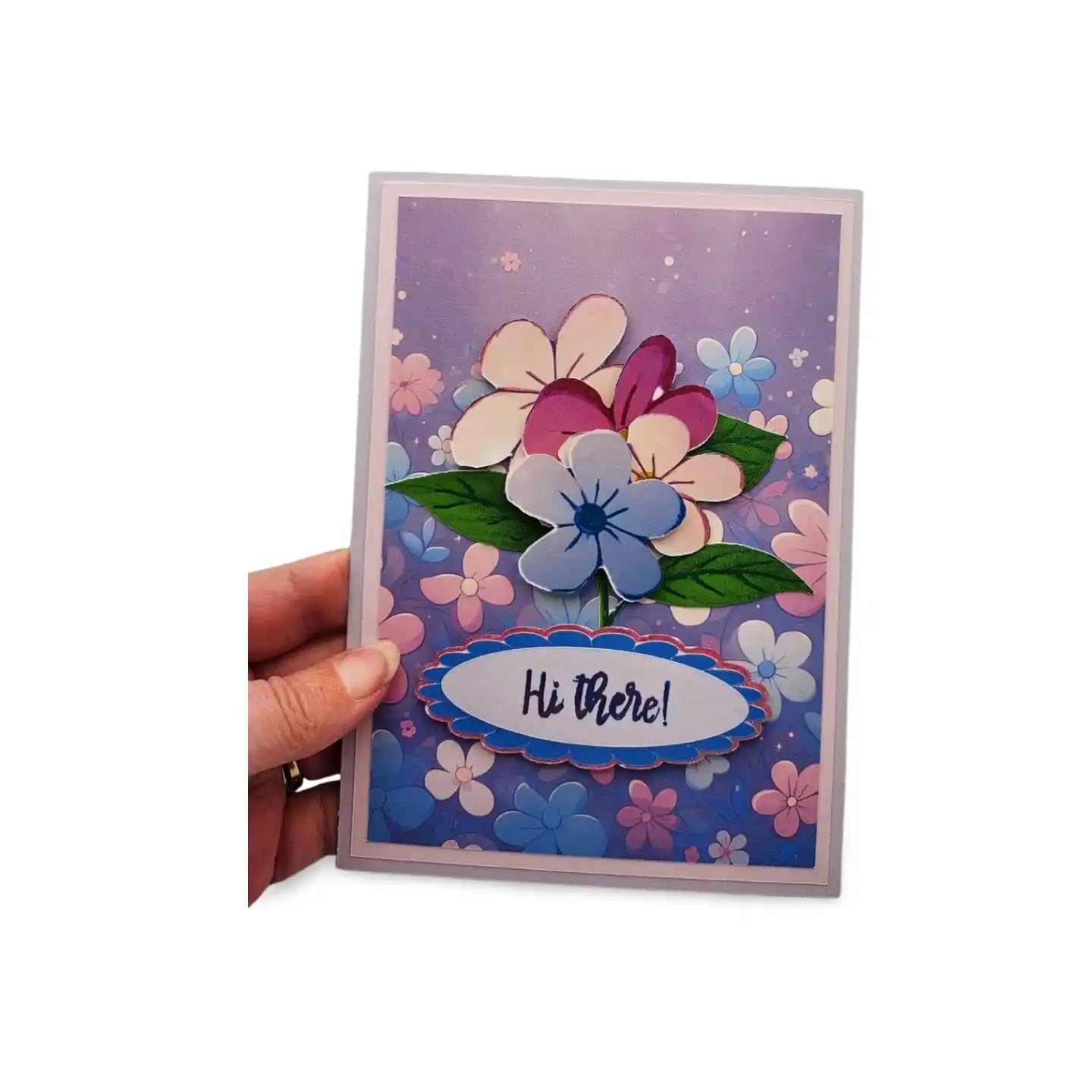 Colorful floral card with 'Hi there!' text held by a hand on a white background