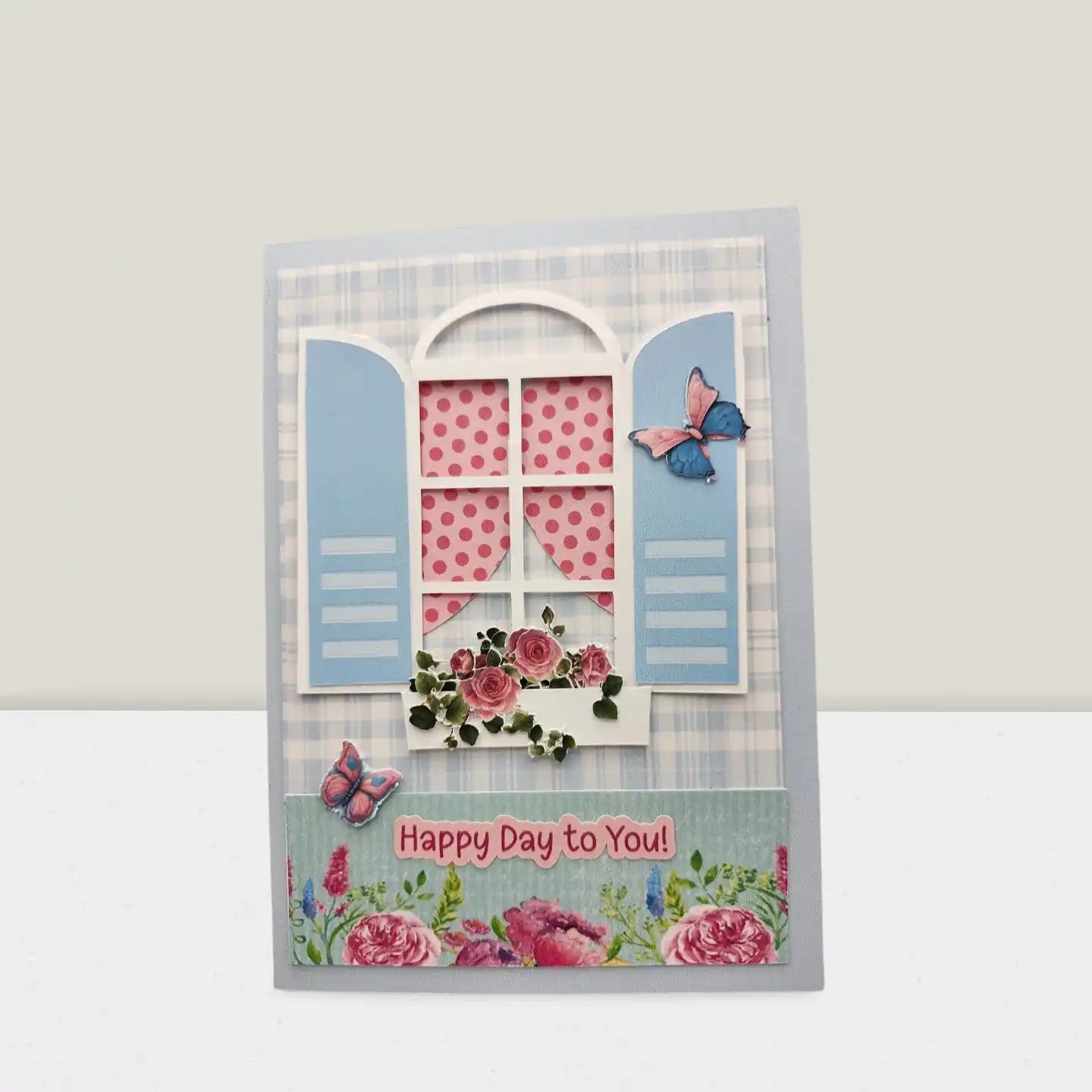 Decorative card with a window design, flowers, and butterflies on a light gray background.