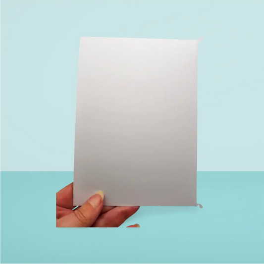 Hand holding a white card against a light blue background