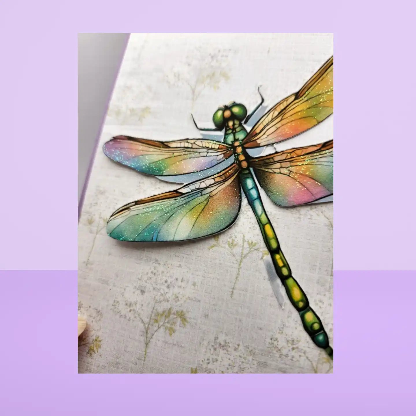 Colorful dragonfly illustration on a textured background with a purple border