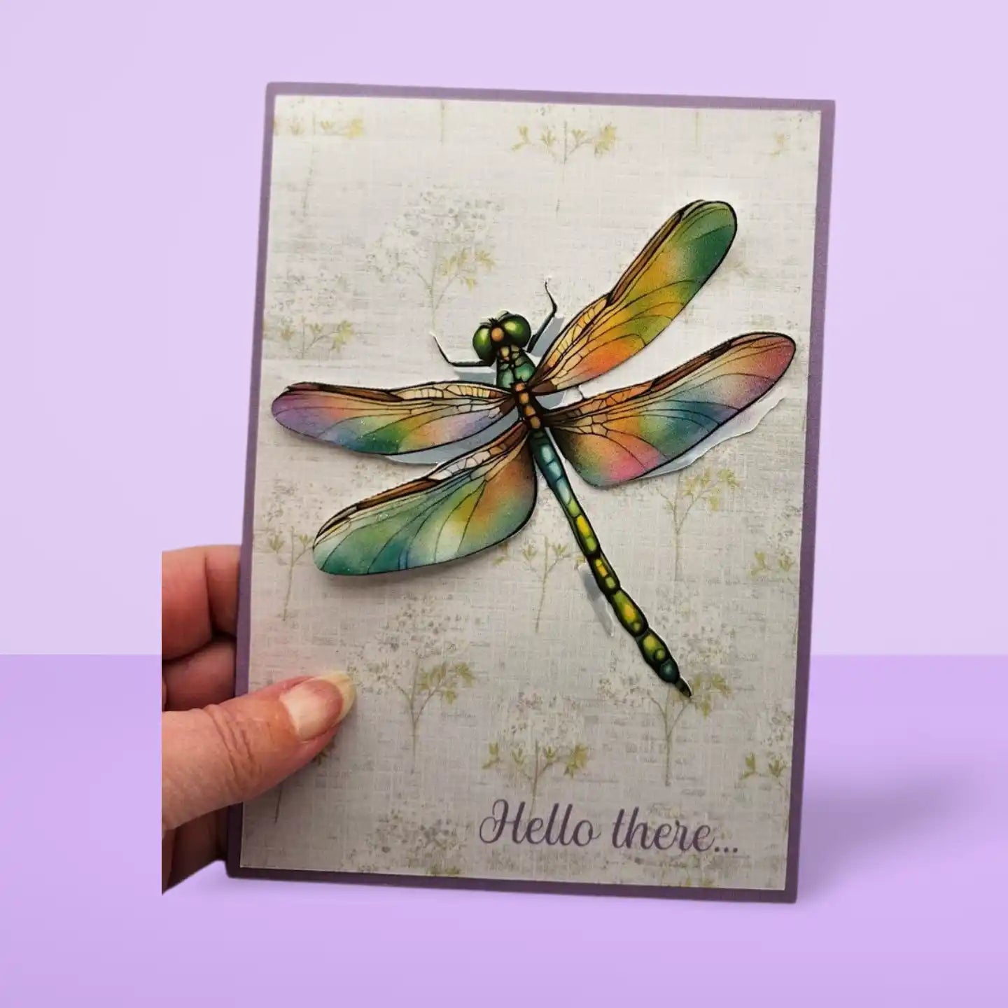 Card with a colorful dragonfly illustration and 'Hello there' text on a light purple background.