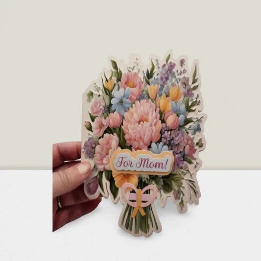 Floral card with 'For Mom!' text held by a hand on a white background