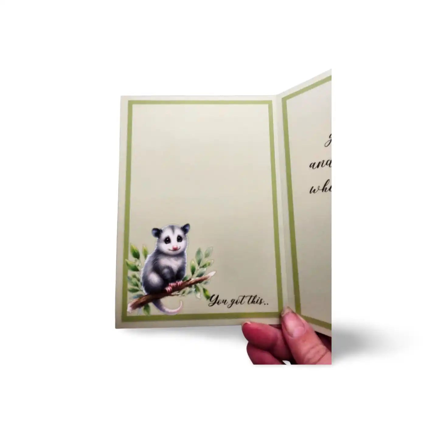 Card with an opossum illustration and text 'You got this' held by a hand.