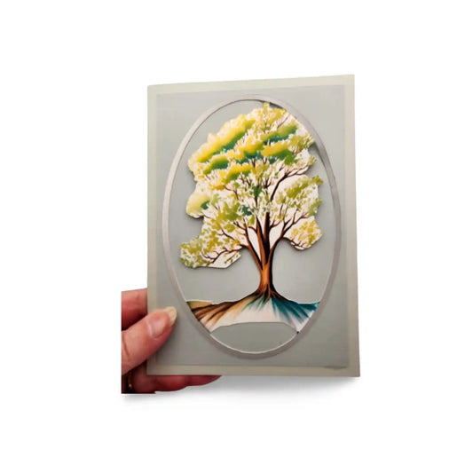Card with a tree design held by a hand on a white background
