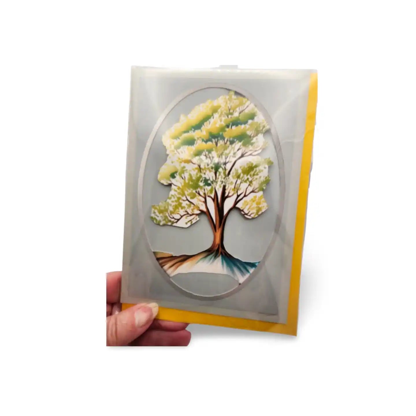 Card with a tree design held by a hand on a white background