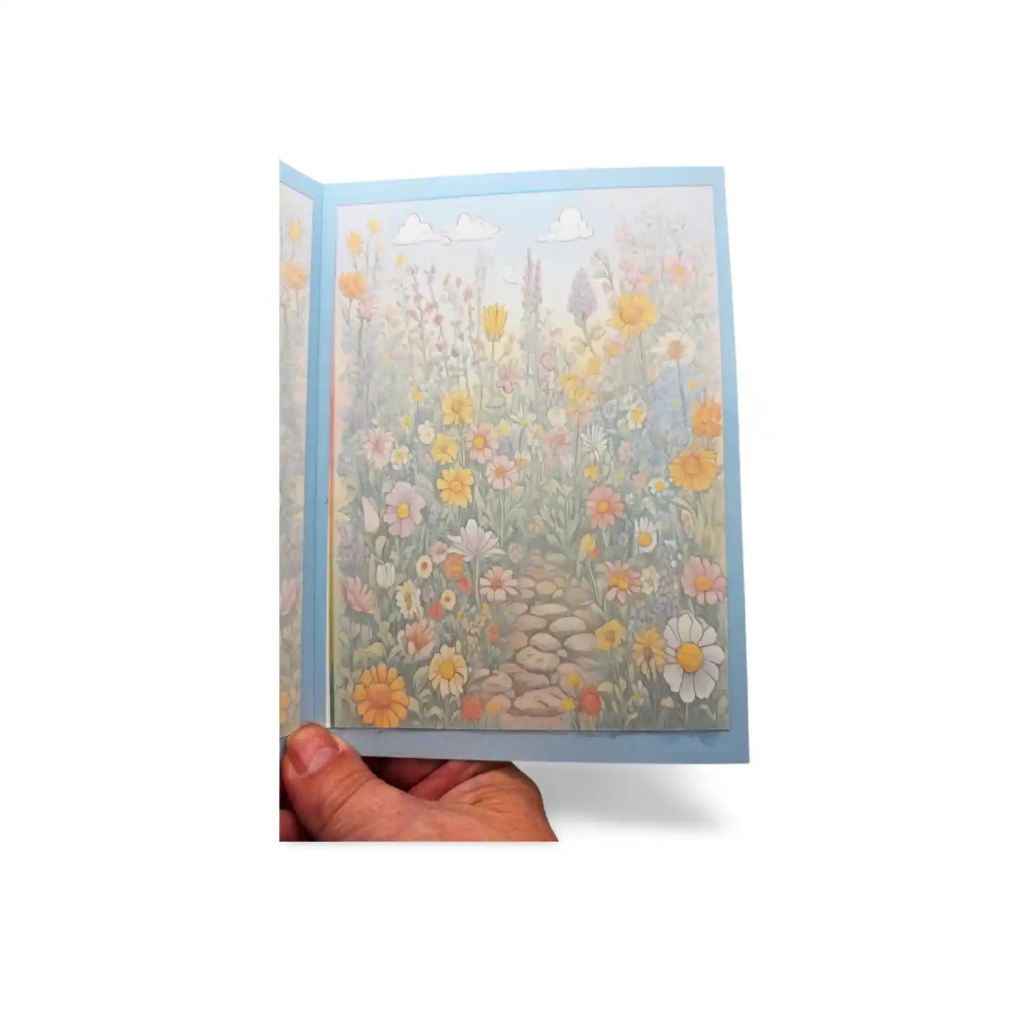 Hand holding a greeting card with floral design on a white background