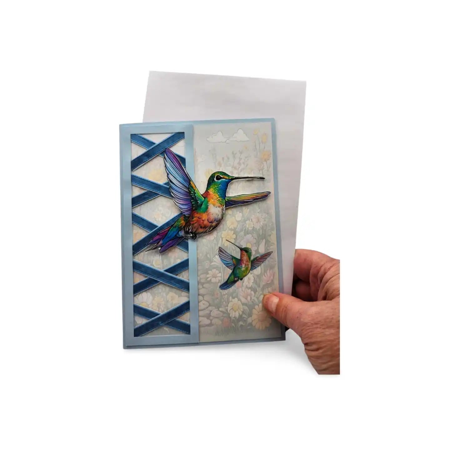 Greeting card with colorful hummingbird design held by a hand on a white background