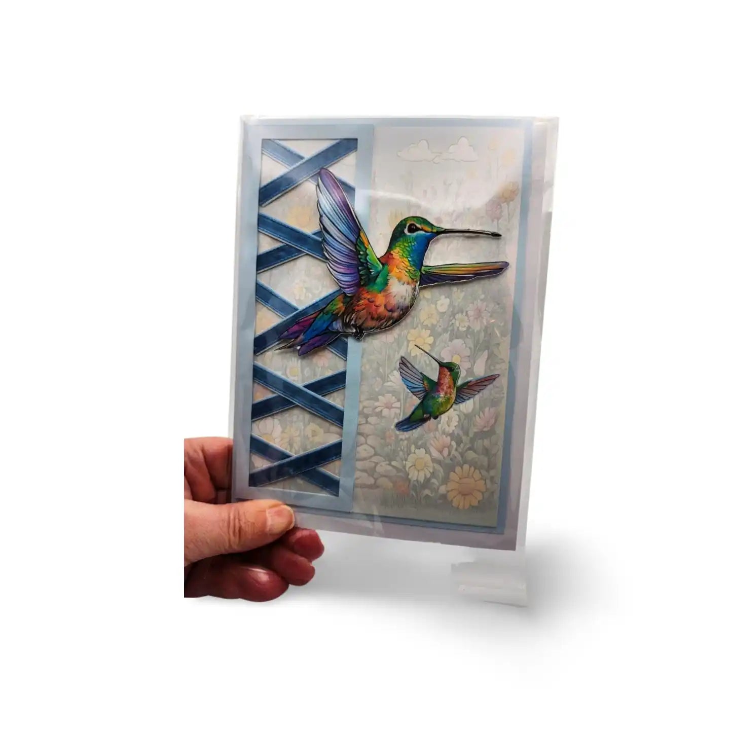 Greeting card with colorful hummingbird design held by a hand on a white background