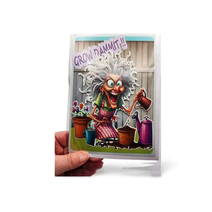 Card with a cartoon character watering plants and the text 'Grow Dammit!' held by a hand on a white background.
