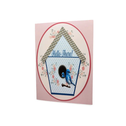Card with a birdhouse design and a blue bird illustration on a pink background