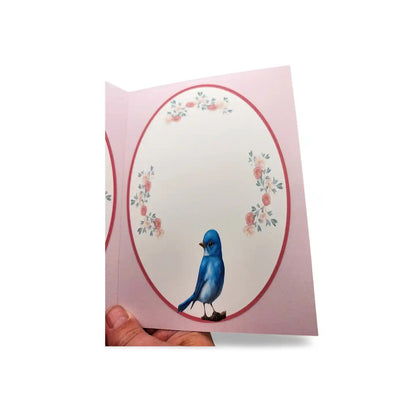 Card with a blue bird and floral design on a pink background