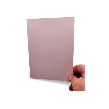 Hand holding a pink card against a white background
