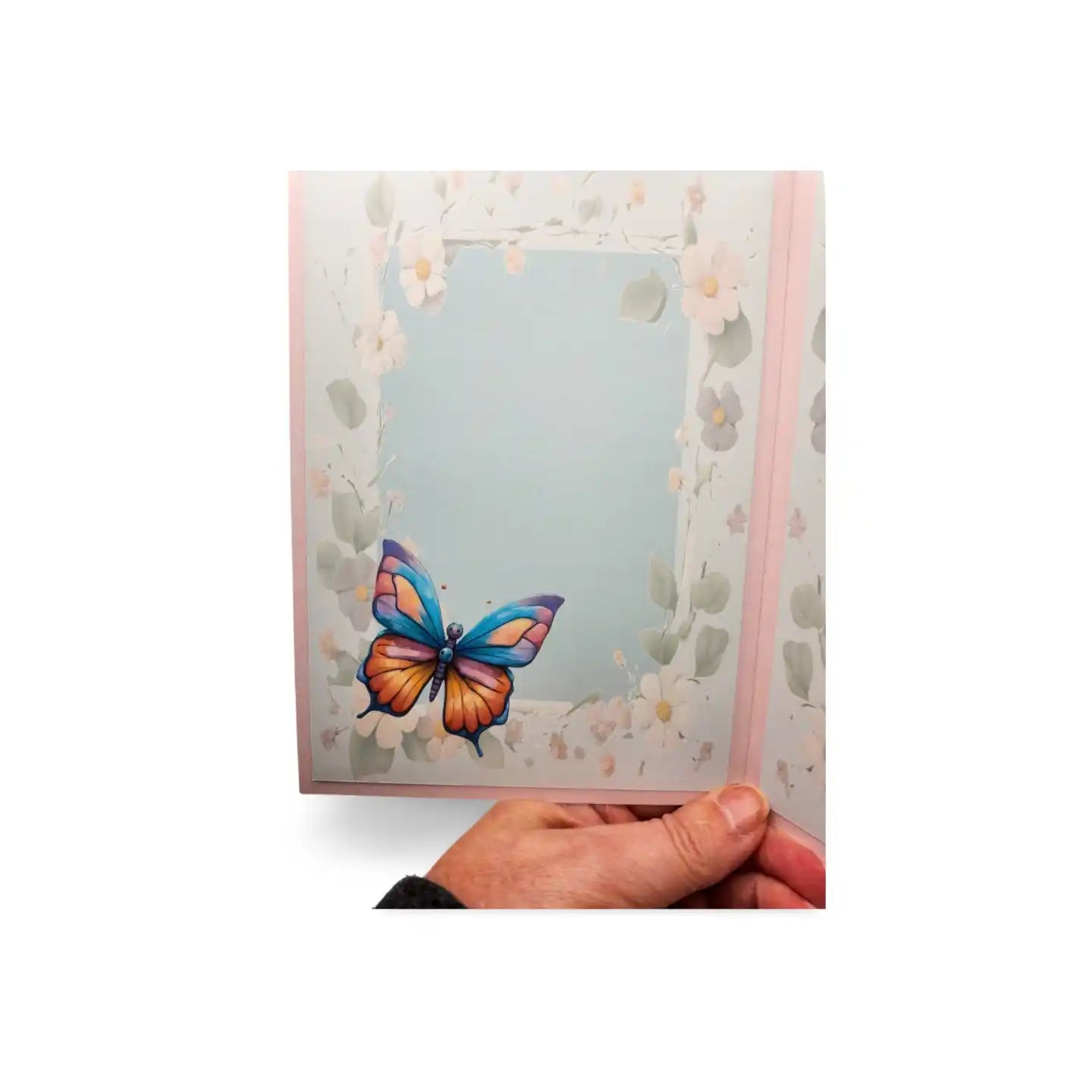 Card with a colorful butterfly design held by a hand against a white background