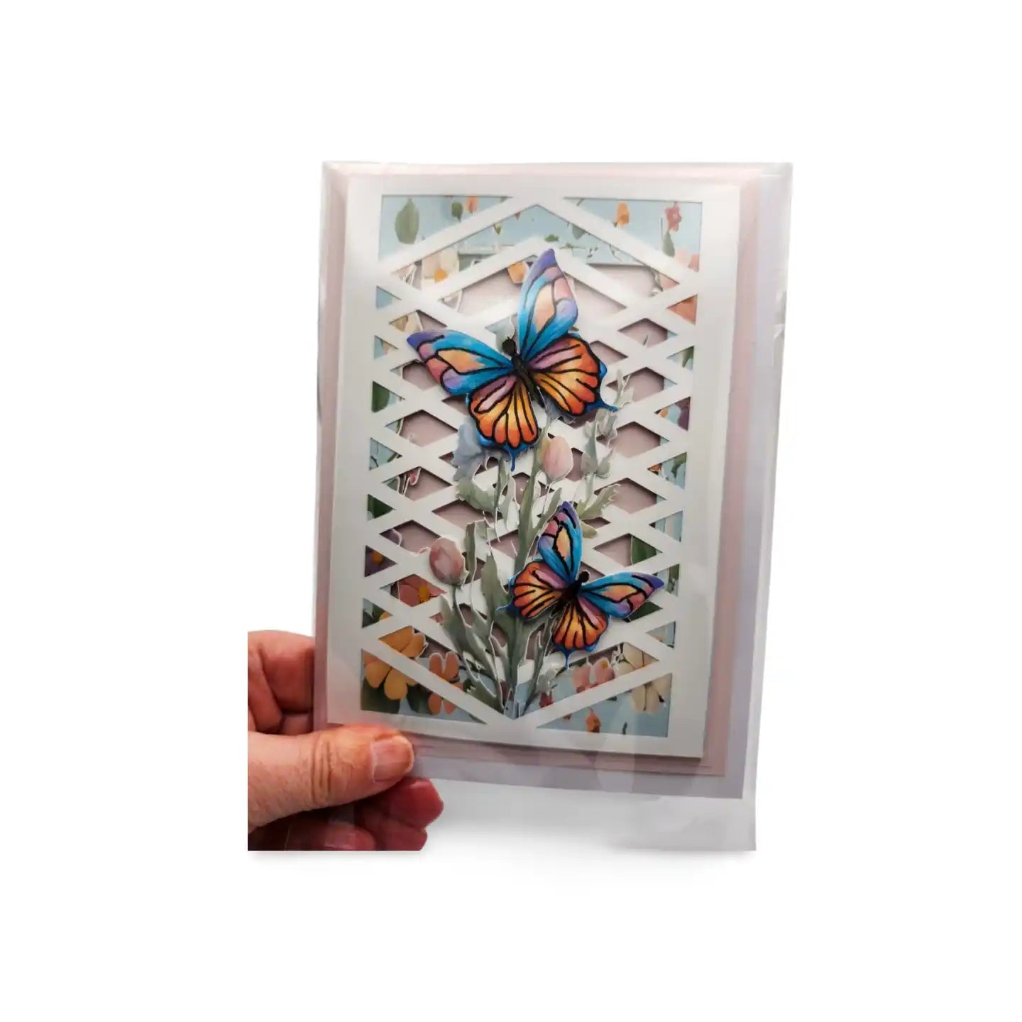 Card with butterfly design held by a hand on a white background