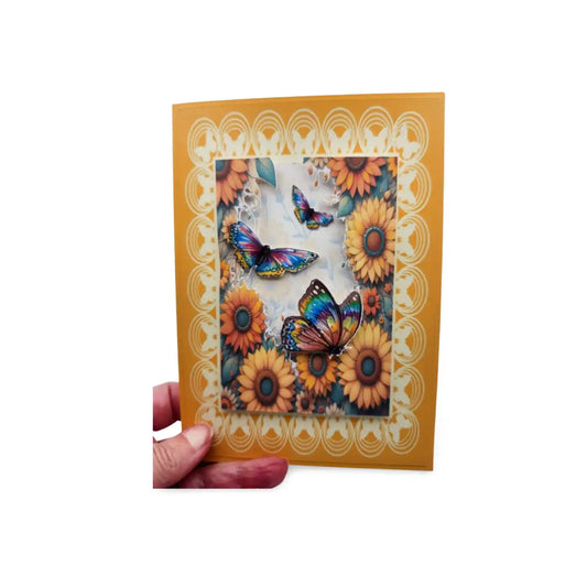 Card with sunflowers and butterflies design held by a hand on a white background