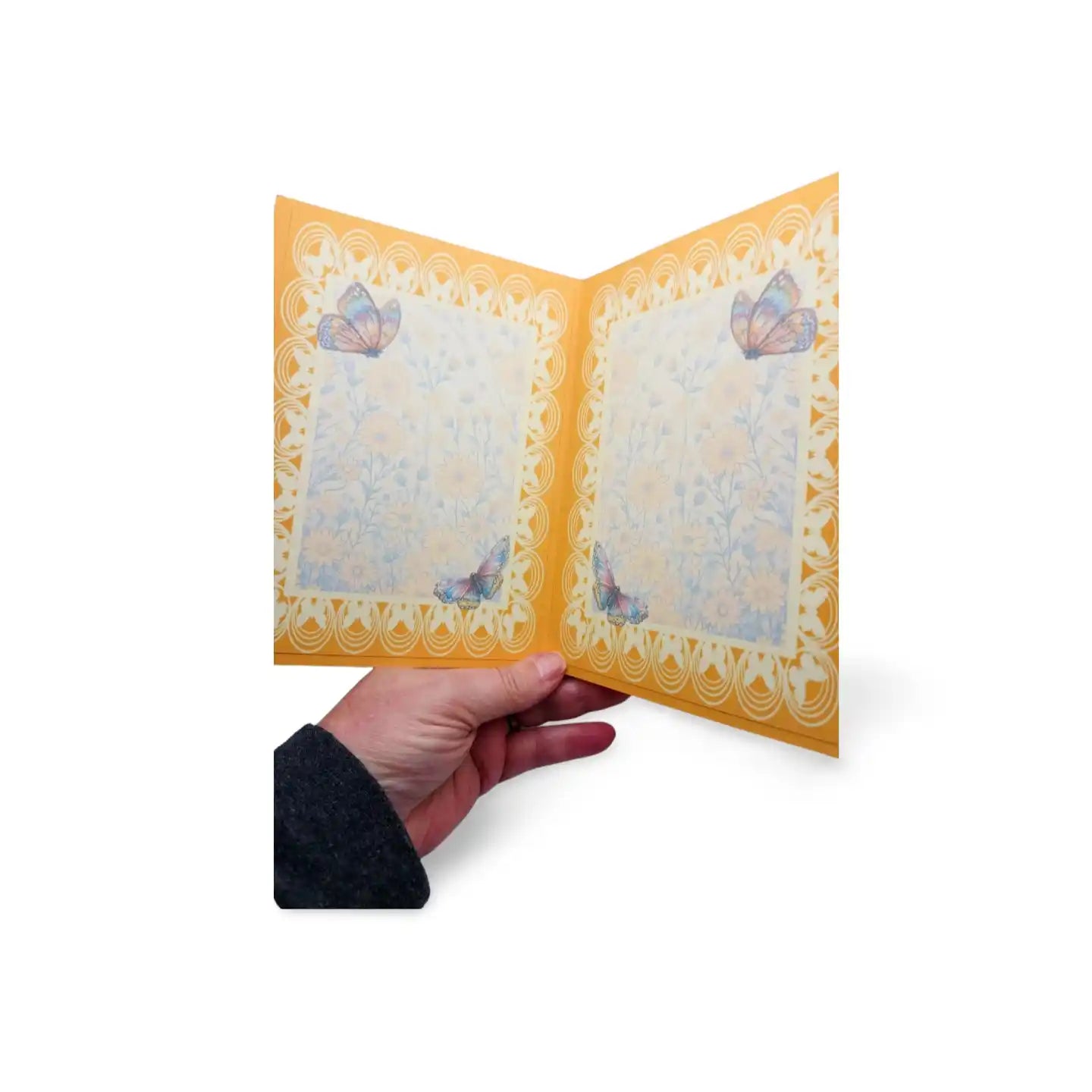 Hand holding a decorative card with butterfly designs on a white background