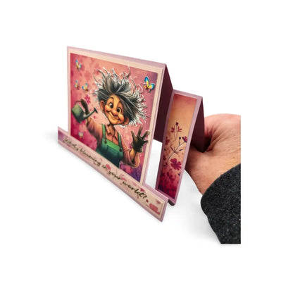 Hand holding a colorful greeting card with a character and text on a white background