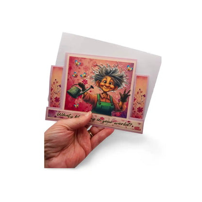 Hand holding a colorful greeting card with a character and text on a white background