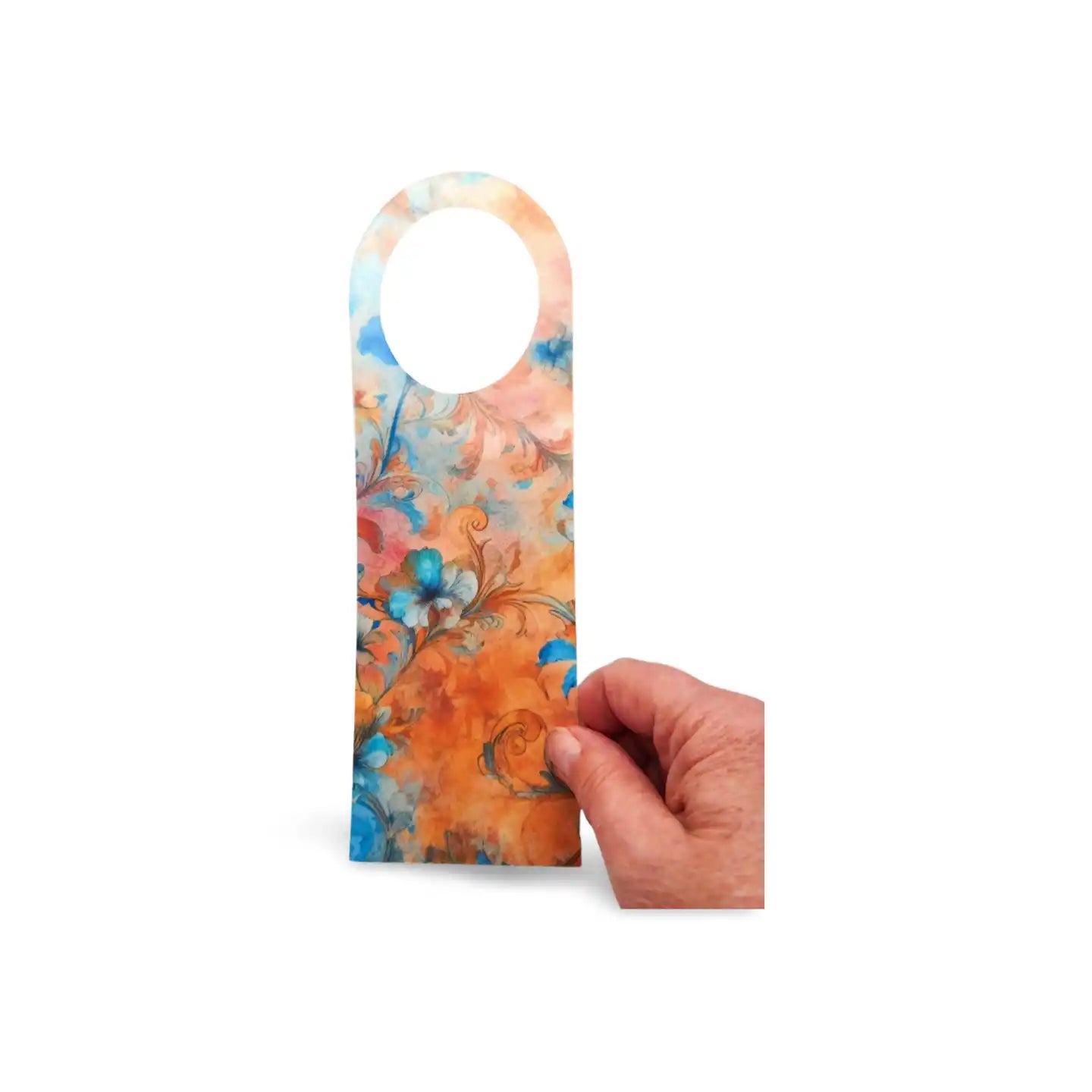 Hand holding a floral door hanger with a hand-painted design on a white background